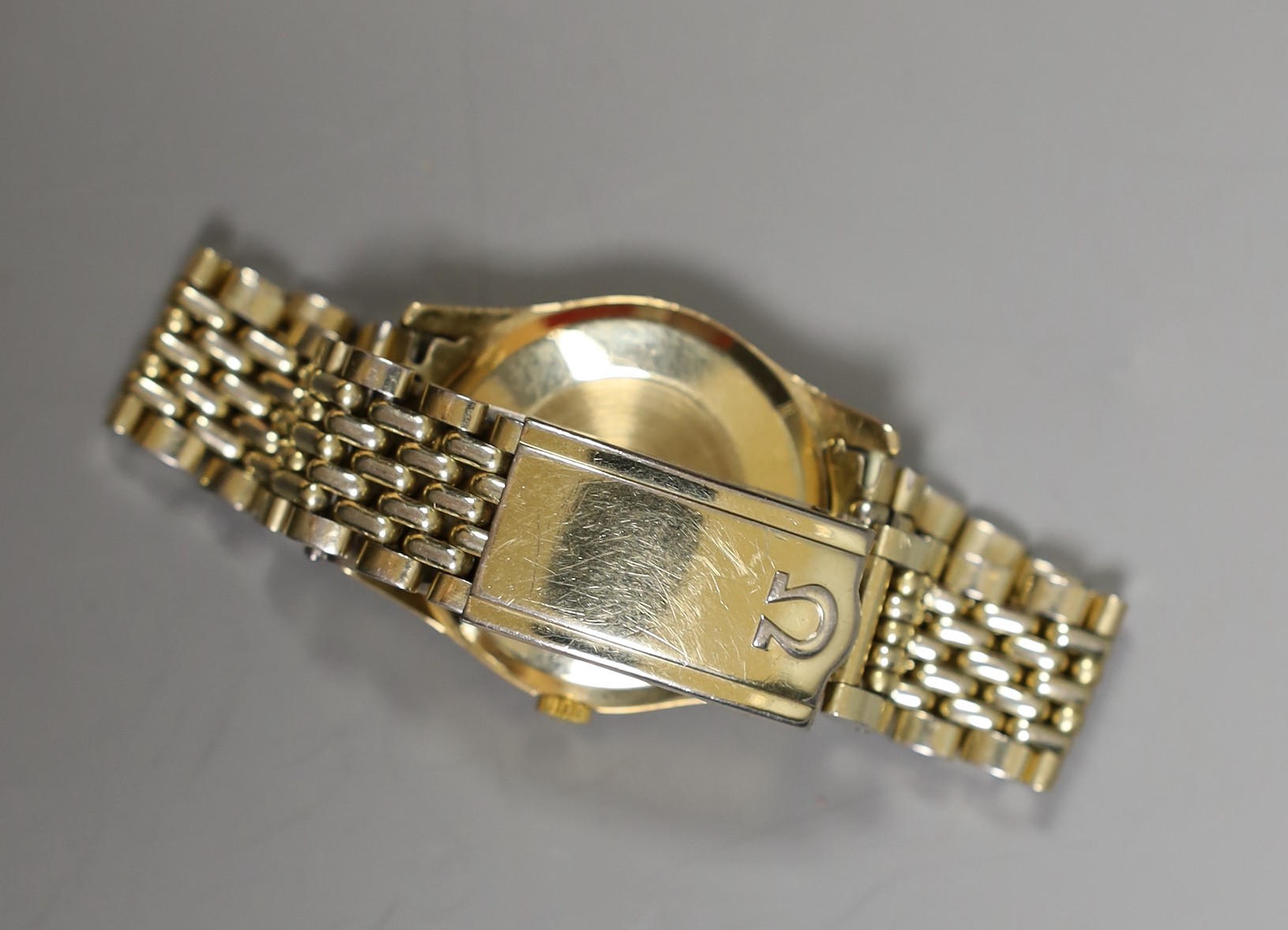 A gentleman's 9ct gold Omega manual wind wrist watch, on an Omega steel and gold plated bracelet, with box and pamphlets.